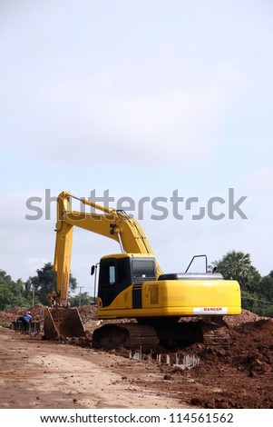 Excavator on working site, moving earth by its bucket