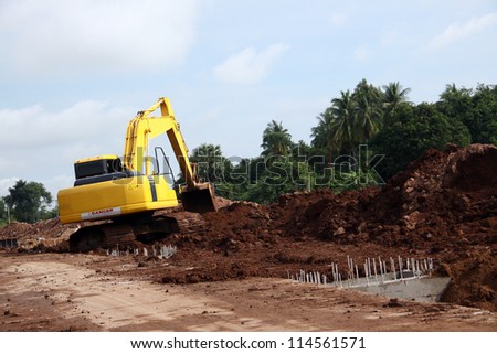 Excavator on working site, moving earth by its bucket
