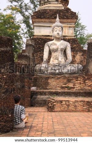 Traveler enjoy drawing picture of ancient buddha in Sukhothai historical park, Thailand