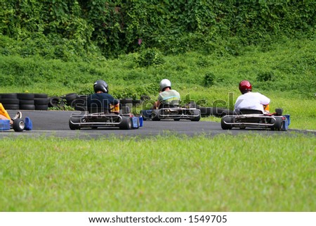 several go karts, racing on a track