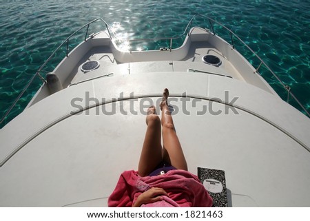 woman lying on top of a catamaran boat anchored on the lagoon