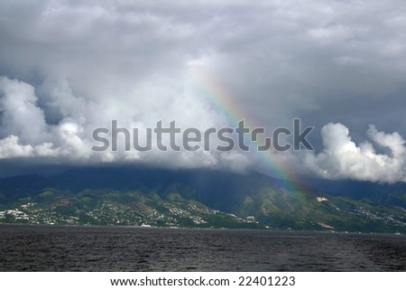 rainbow on a tropical island from a sail boat