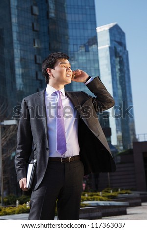Young businessman talking on mobile phone.