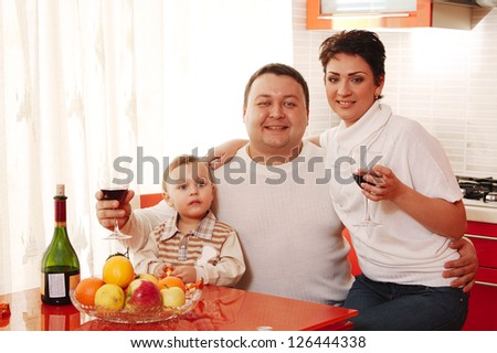 Family in home kitchen drinking wine