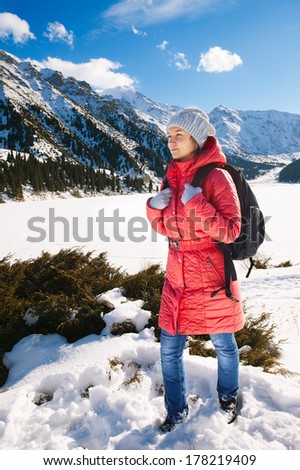 Young woman take a walk on winter mountain slope (Big Almaty Lake, Kazakhstan)