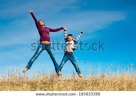 Active family - mother and kid jumping outdoor
