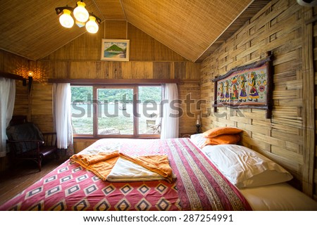 KOH NANG YUAN , THAILAND - June 20, 2014: Rural style bedroom with canopy bed with sea view, bamboo decorated. Very popular tourist resort area.