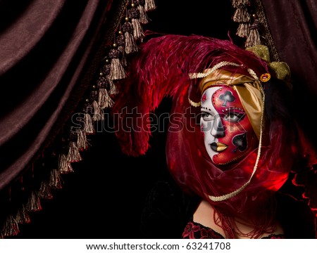 Beautiful girl with playing cards and cool Venetian mask makeup over vintage interior