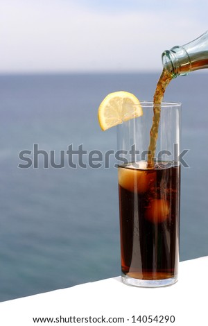 a cold refreshment at the sea, glass of cola