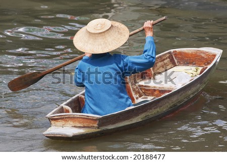 Man in boat floating through the canals of Bangkok