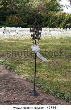 A lamp at the entrance to an outdoor wedding