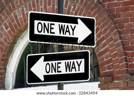 Two one-way signs showing two different directions