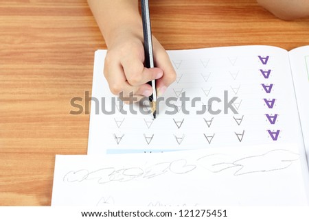 Child hand writing alphabet A, Homework