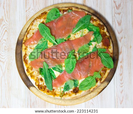 Smoked salmon pizza top view on wood table