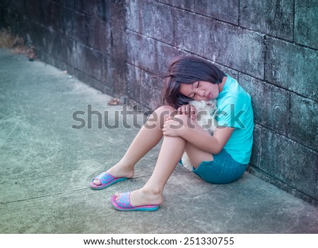 portrait of sad and lovely Asian girl against grunge wall background
