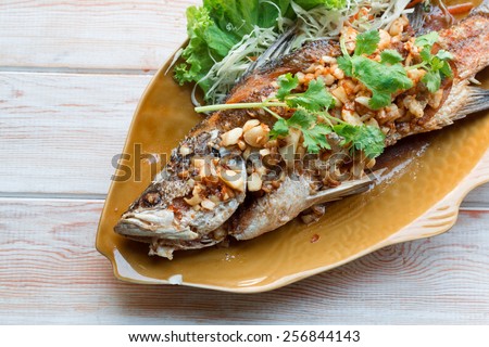 Thai style food main course: whole fried sea bass with garlic