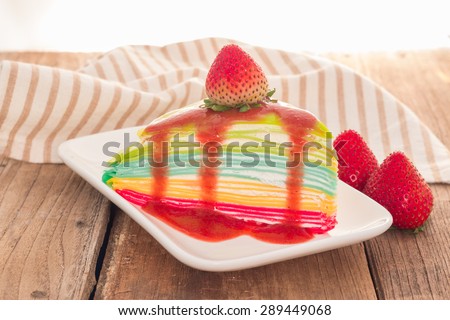 Rainbow crepe cake with strawberry juice and fresh strawberry on top