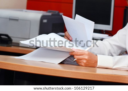 a worker man analyzing pile of paper