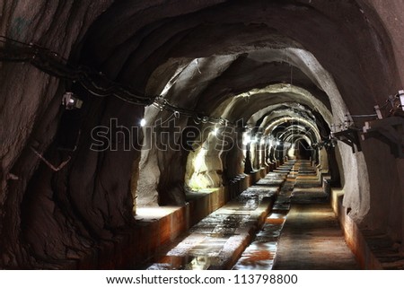 long walk way in dark tunnel with light
