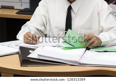 Businessman writing paper in file , he is busy