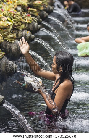 BALI, INDONESIA - MAY 6: Worshippers make an offering at the Tirta Empul Temple on May 6, 2013 in Bali, Indonesia. They believe that water from the spring is holy and has the healing power.