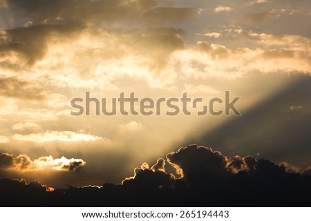 Sun ray beam behind cloud over sky