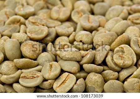 Background texture of green un-roasted coffee beans.