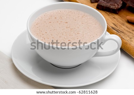 Mexican hot chocolate with chocolate and cinnamon on wooden board.