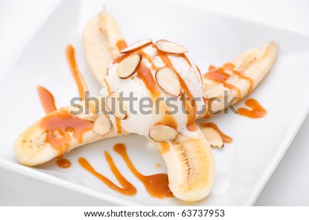 Vanilla ice cream and bananas topped with caramel sauce and almonds.