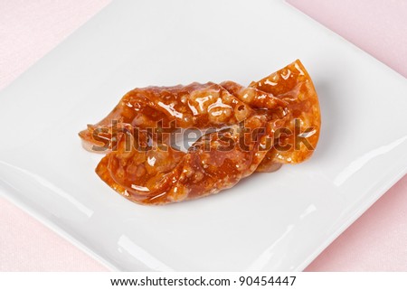 A single sticky butterfly cookie on a small plate on a pink napkin.