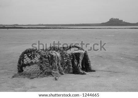 Black & white landscape showing washed up lobster pot near to Lindisfarne.