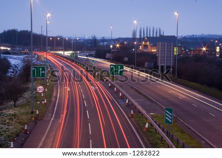 Cars slamming on their brakes as they approach road works and speed restrictions. Blurred over long shutter delay at dusk.