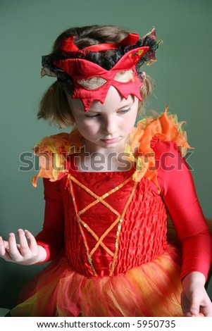 Young girl looking perplexed in red and orange Devil costume.