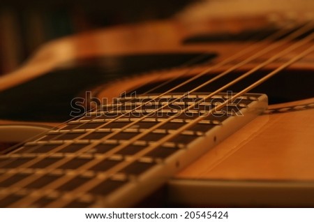 Acoustic guitar body and fret board close up.