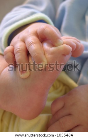 Baby hand clasping foot