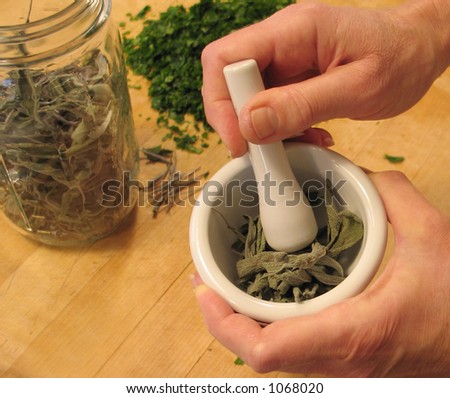 Grinding dried herbs with a mortar and pestle