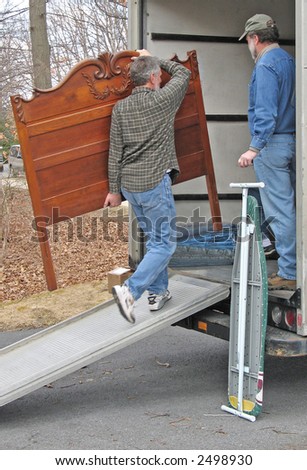 Man carries a headboard onto a moving van