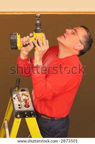 Man using drill to install track lighting