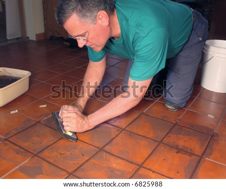 Man grouting ceramic tile