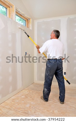 Man painting room with roller attached to an extension pole