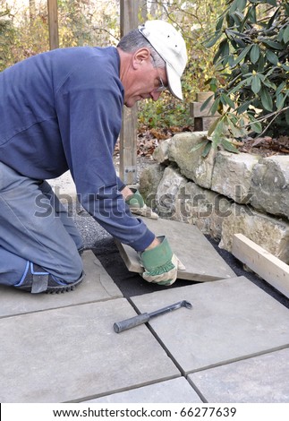 Man installs flagstone pavers on patio
