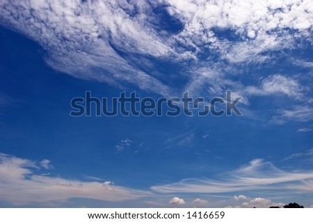 Blue sky, skies with feathery white clouds. Some space of blue is available for text and illustrations. A sense of wide open space, if cropped to panoramic.
