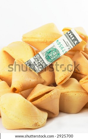 Chinese Fortune Cookie on a heap with money, cash neatly folded inside the snack, on white background, many behind, to show one out of many.