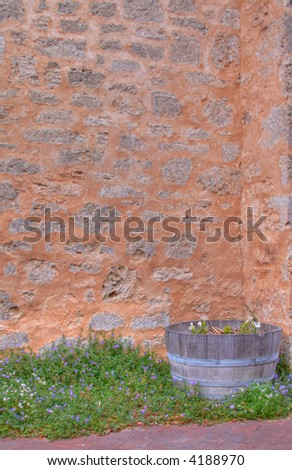 Unique High resolution textured brick wall with barrel and flowers for background image, grainy nature is due to concrete, not image noise