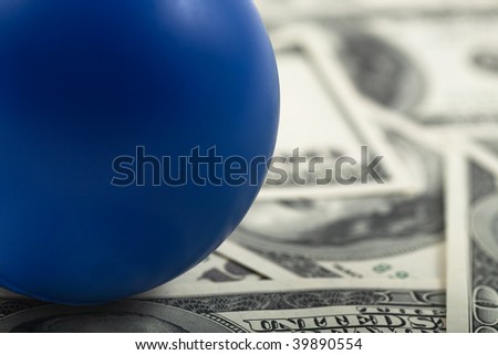Closeup of Blue ball on stack of cash. Text space on blue ball.