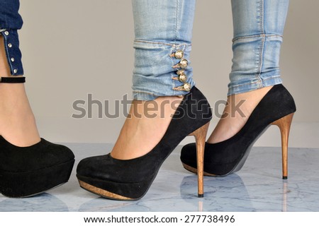 Encounter between two women - Image of two women in jeans and heeled shoes