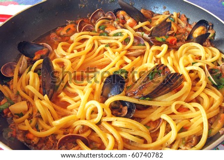 A pan of fresh pasta with seafood prepared and ready for the table