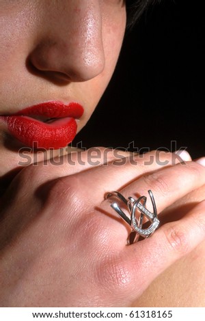 Woman\'s face in the foreground with lipstick and jewelry