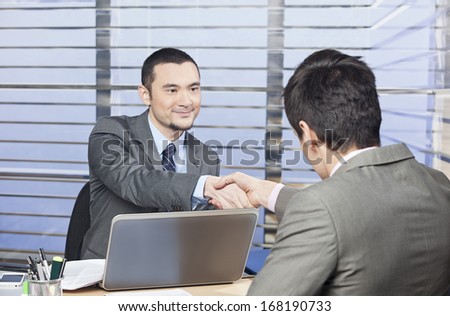 Young consultant shaking hands with his client