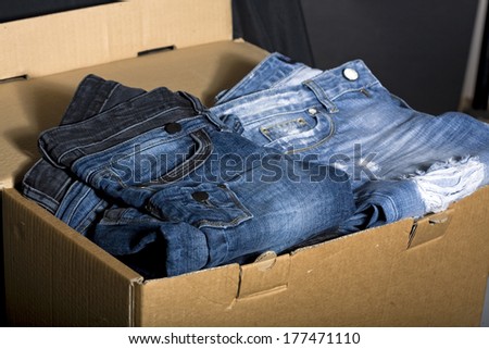 Pile of blue jeans stacked in the cardboard box